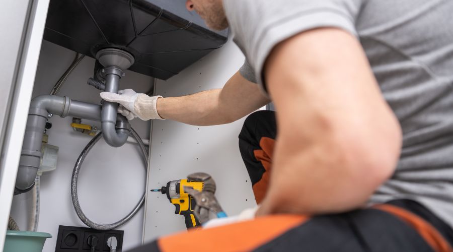 plumber working on a plumbing issues in the sink drain
